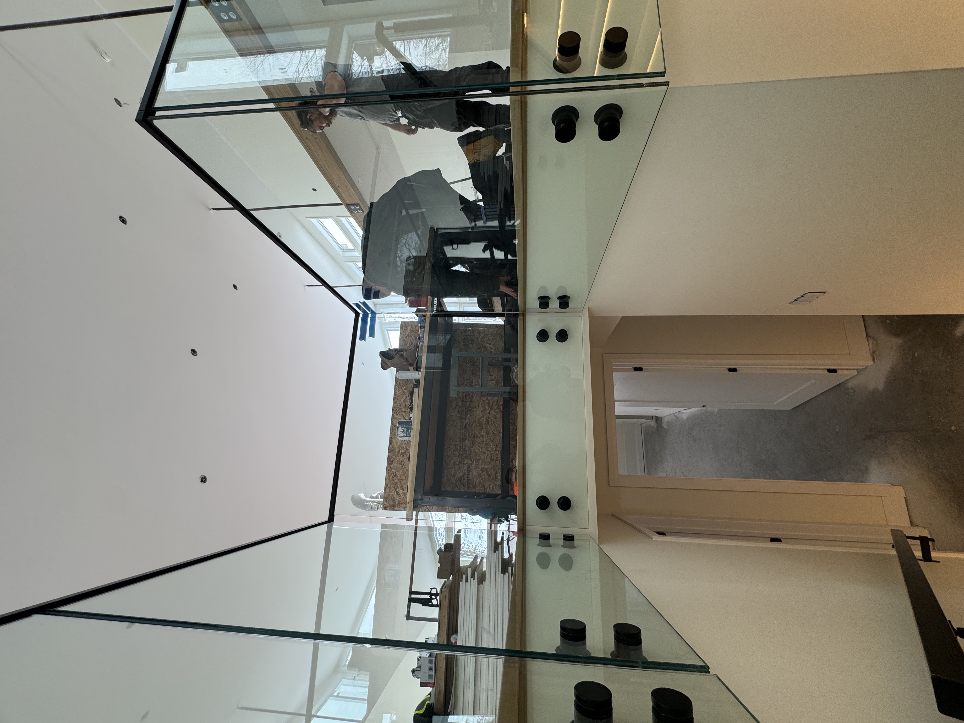 Glass railing panels installed around a stair opening