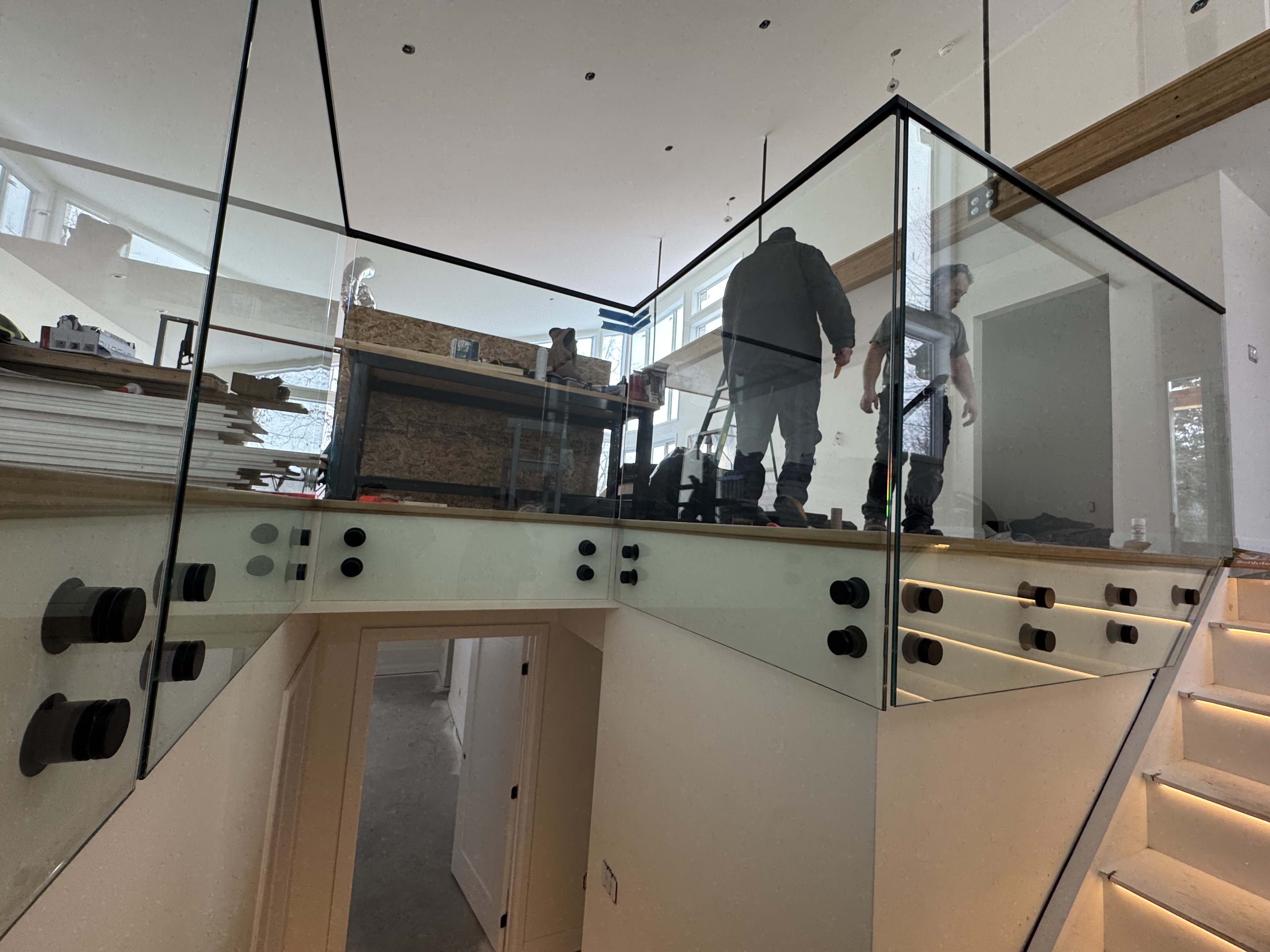 Modern clear glass stair railing with black hardware