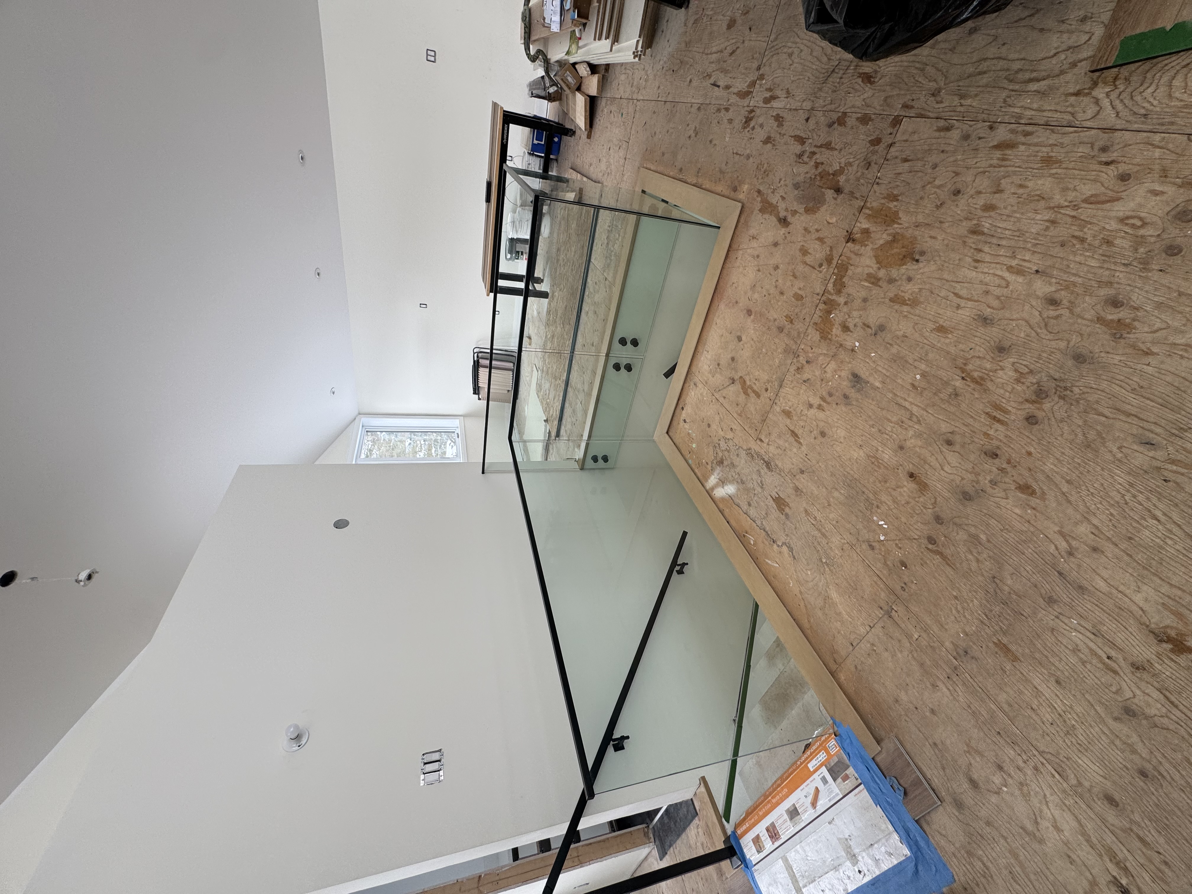 Glass railing under construction with clean black trim