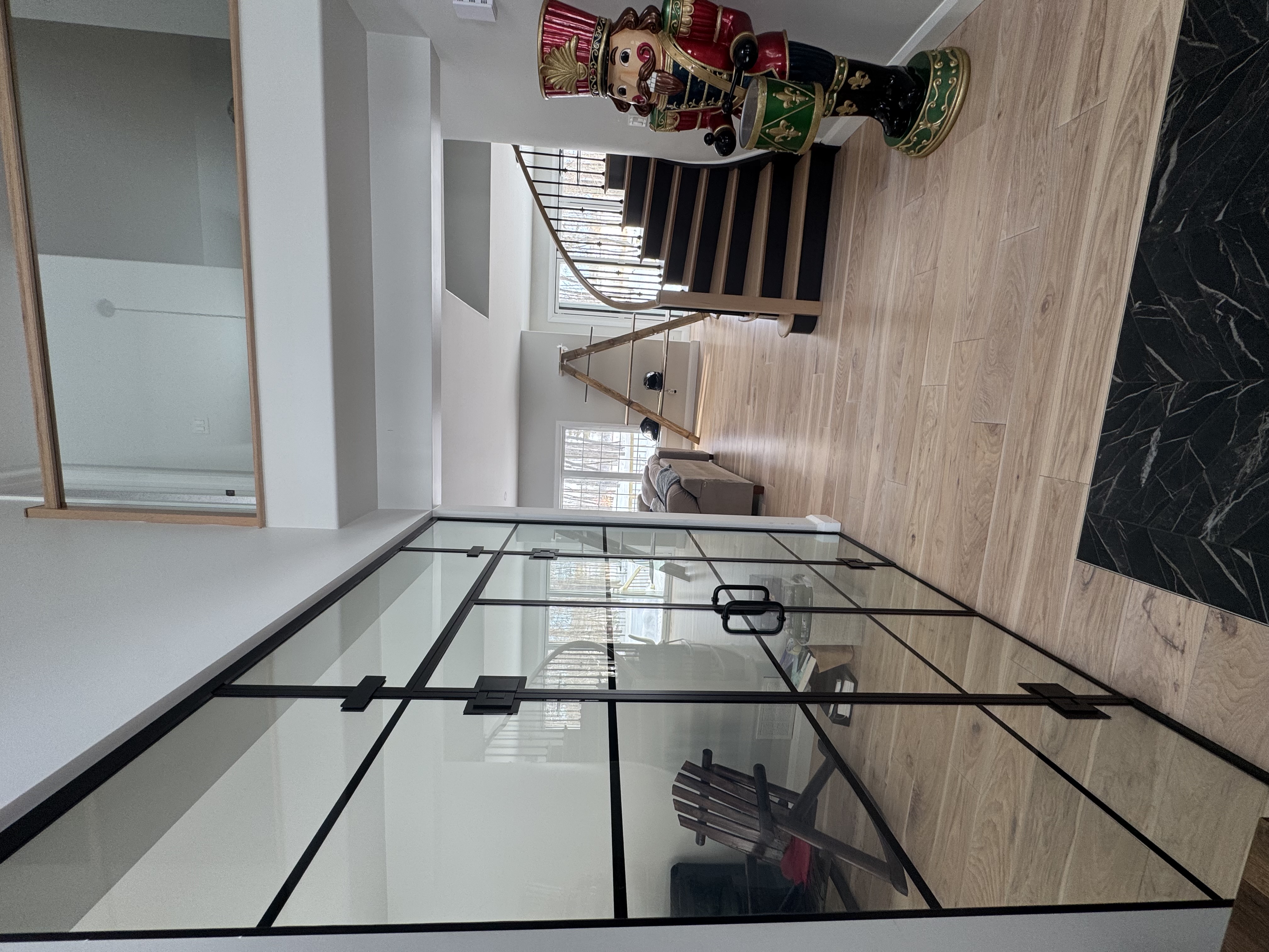 Glass doors and hallway with black trim and wood floors